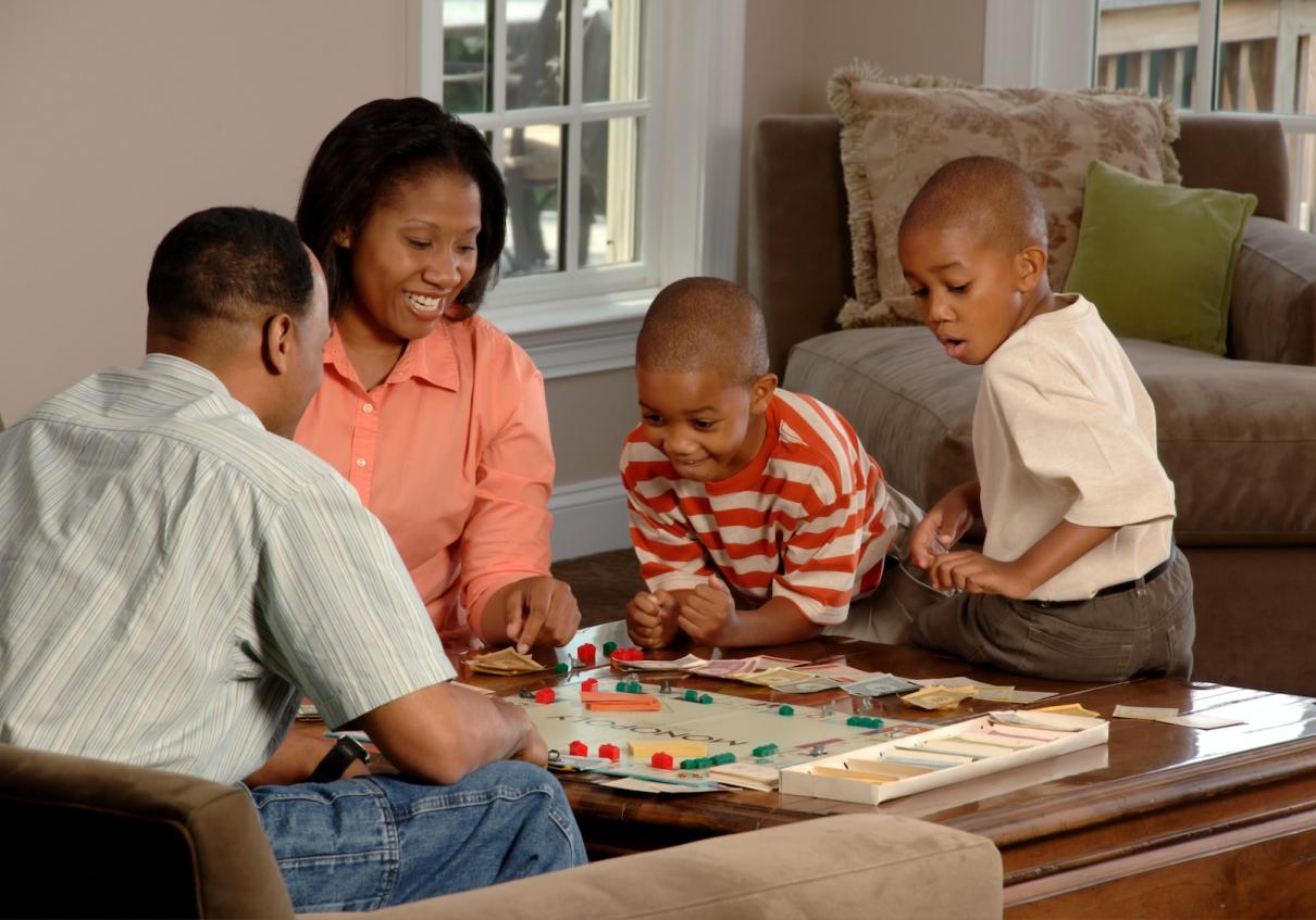 family playing a board game in a living room