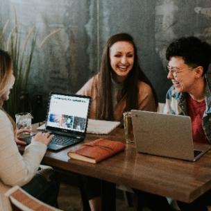 women laughing over laptops