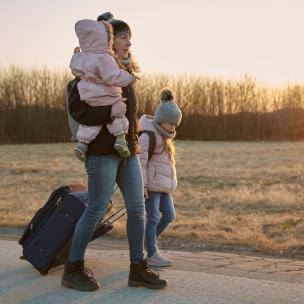 Family walking with rolling suitcase.