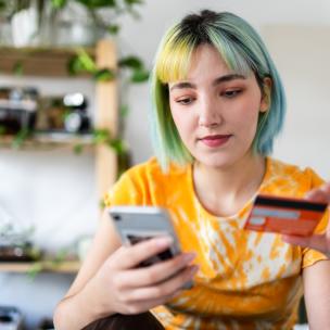 Young woman with colored hair using a gift card